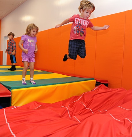 kids jumping into foam pit gym party text image block-min