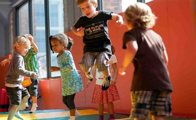 Children jumping together on the Tumbl Trak in the Kidville Upper West Side gym
