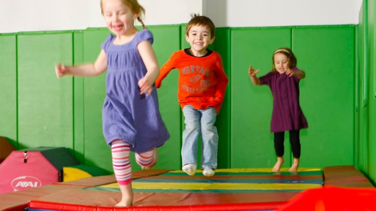 Kids running and jumping on the Tumbl Trak during a gym class at Kidville Upper West Side